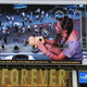 Illustration for article titled 50-Foot Models Invade Times Square Billboard With Polaroids And Kisses